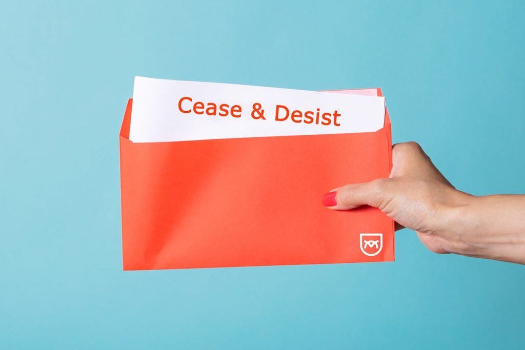 A hand holding a red envelope with a paper labeled “Cease & Desist” sticking out; Sapience Law shield icon appears on the envelope.